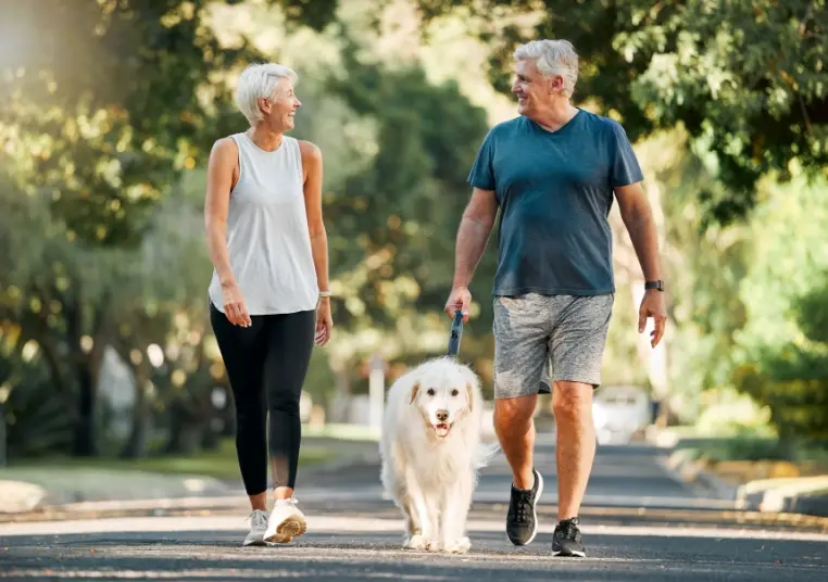 Paar mit Hund beim Gassi gehen